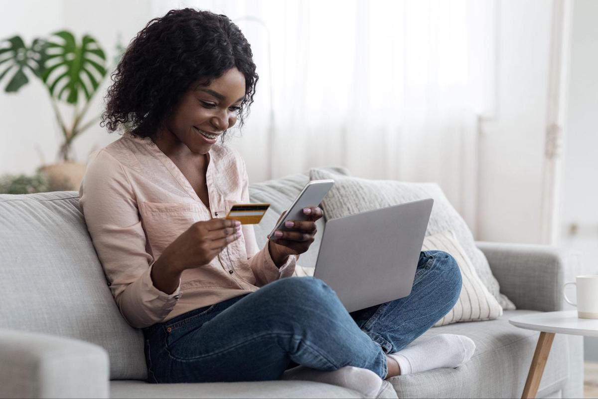 Woman holding a credit card and using a phone